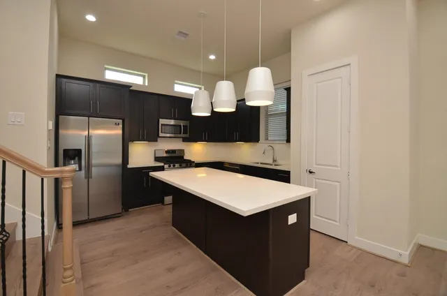 a kitchen with a sink a counter top space and stainless steel appliances
