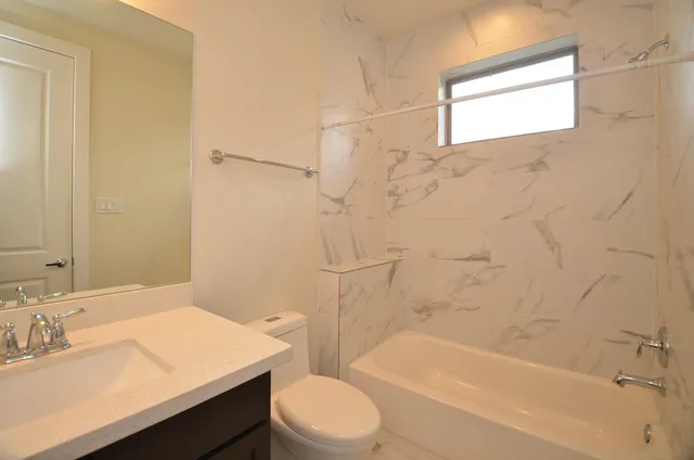 a bathroom with a sink toilet vanity and shower