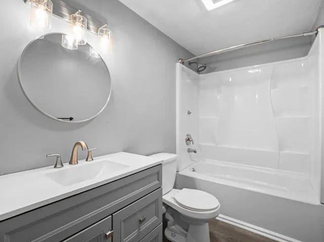 a bathroom with a sink a toilet and a mirror