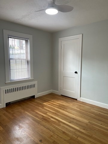 9 Common Street, Unit 1 Quincy, MA 02169 - Photo 12 of 16 an empty room with wooden floor and windows