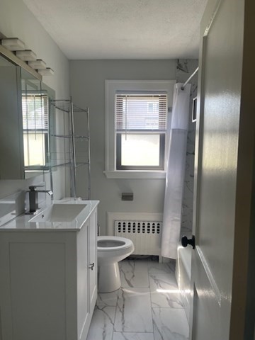 9 Common Street, Unit 1 Quincy, MA 02169 - Photo 14 of 16 a bathroom with a sink toilet and shower