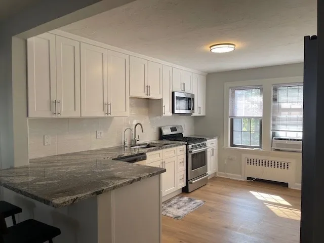 a kitchen with granite countertop a sink stove and cabinets