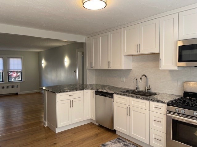 9 Common Street, Unit 1 Quincy, MA 02169 - Photo 4 of 16 a kitchen with granite countertop a sink a stove and cabinets
