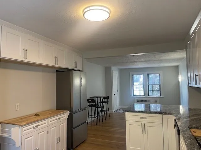 a kitchen with granite countertop a stove a sink and a refrigerator