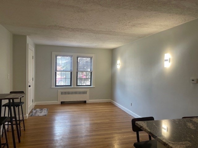 9 Common Street, Unit 1 Quincy, MA 02169 - Photo 8 of 16 an empty room with wooden floor and windows