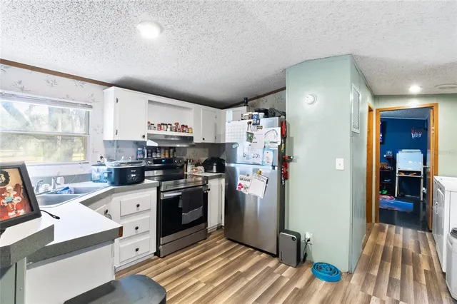 a bed sitting in a bedroom next to a window with wooden floor