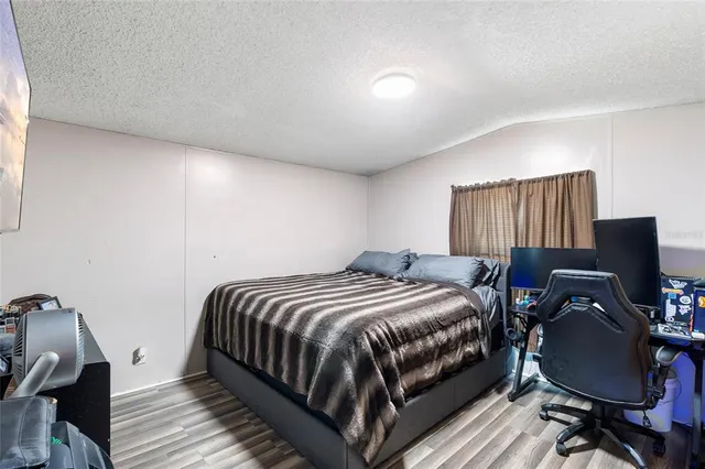 a bedroom with a bed and wooden floor