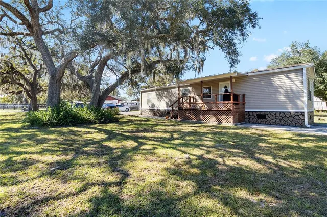 a view of a house with large trees and a big yard