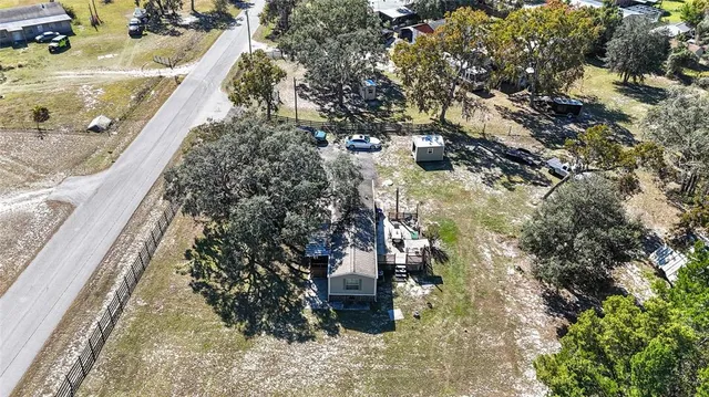 an aerial view of residential houses with outdoor space and parking