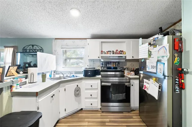 a kitchen with stainless steel appliances granite countertop a refrigerator and a stove top oven