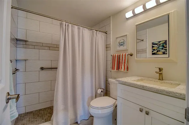 a white toilet sitting next to a shower