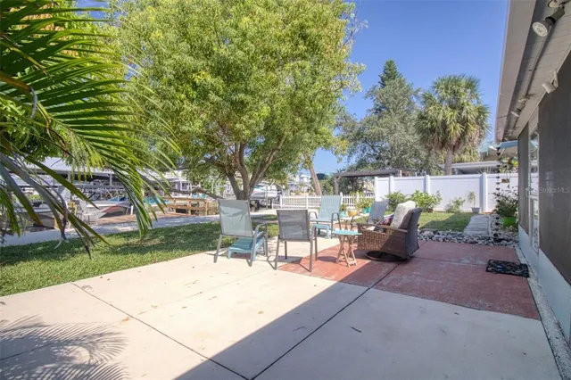 a view of a chair and table in backyard of the house