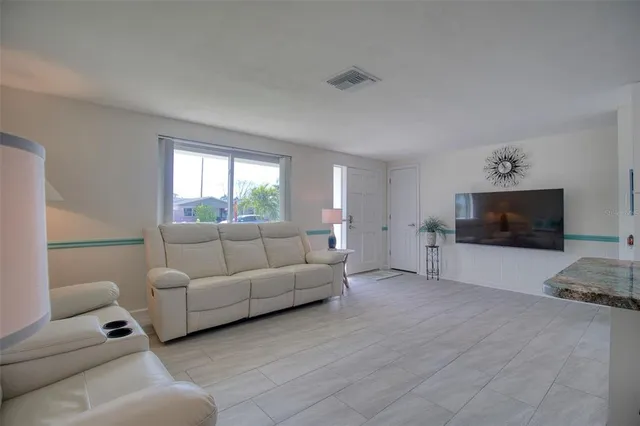 a kitchen with kitchen island a counter top space a sink a refrigerator and cabinets