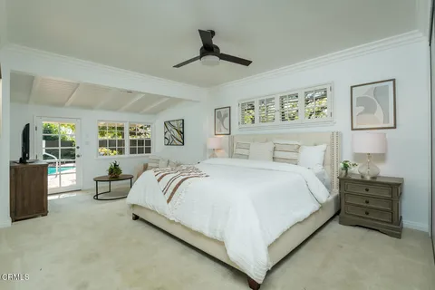 a bedroom with a large bed and a potted plant