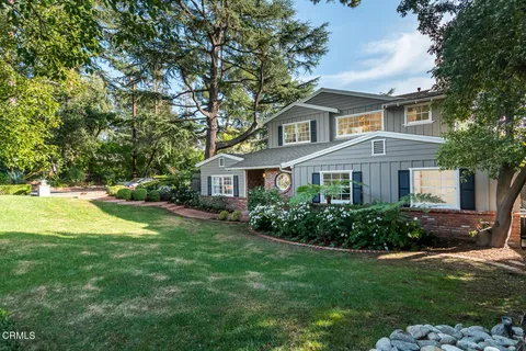 a front view of a house with a yard and trees