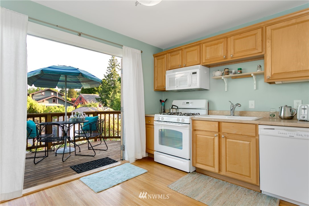 731 North 68th Street Seattle, WA 98103 - Photo 14 of 25 a kitchen with stainless steel appliances granite countertop a stove a sink and a microwave