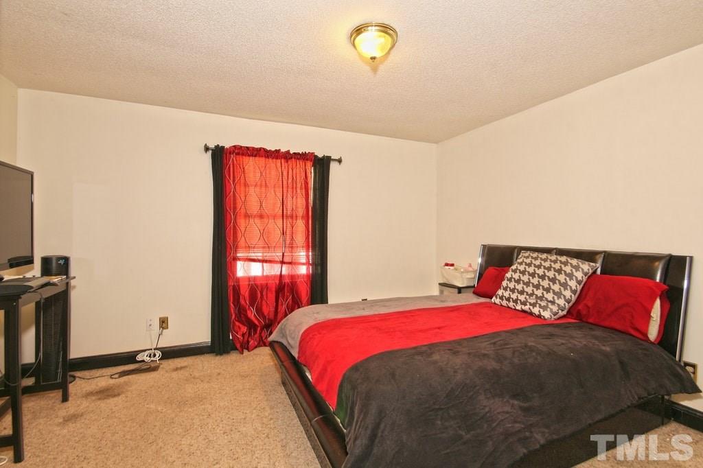 2908 New Hope Church Road Raleigh, NC 27604 - Photo 17 of 24 a bedroom with a bed and a flat screen tv