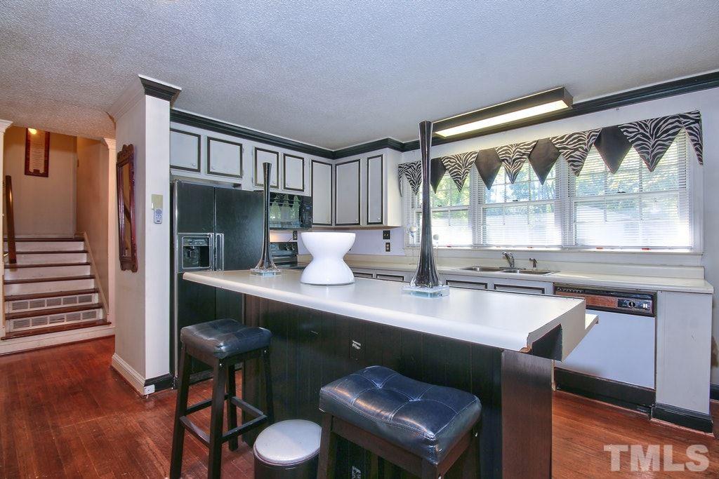 2908 New Hope Church Road Raleigh, NC 27604 - Photo 7 of 24 a kitchen with a table chairs stove and wooden floor