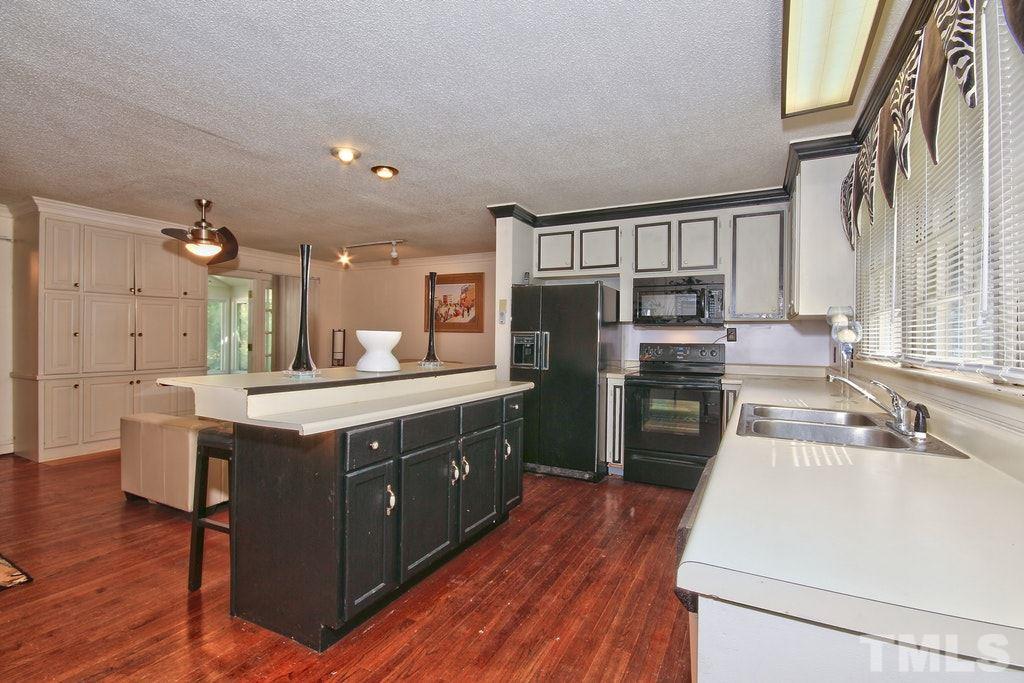 2908 New Hope Church Road Raleigh, NC 27604 - Photo 8 of 24 a kitchen with stainless steel appliances granite countertop a sink a stove and a wooden floors