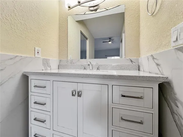 a bathroom with a granite countertop sink vanity and mirror
