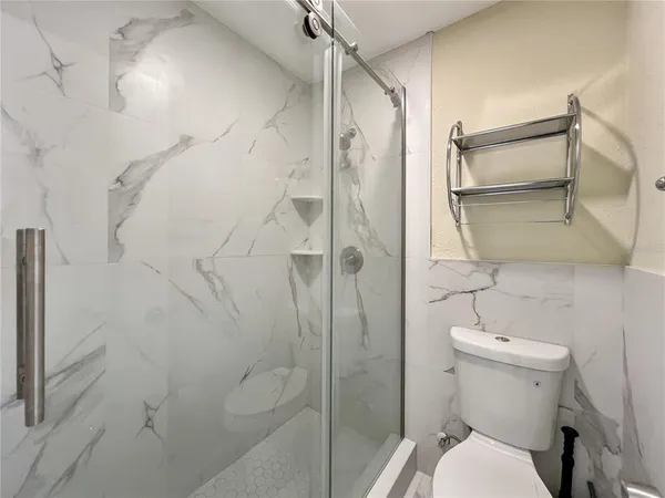a bathroom with a toilet and shower