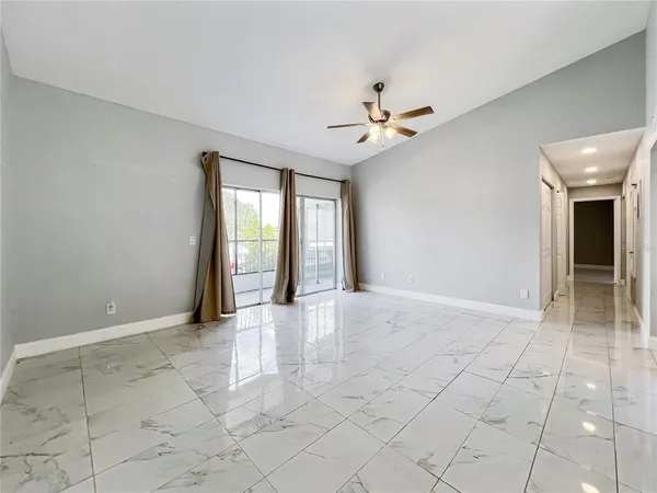 an empty room with windows and fan