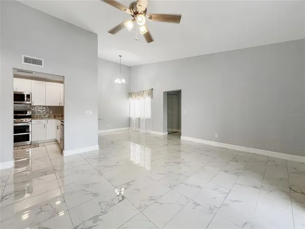 a view of empty room with wooden floor and window
