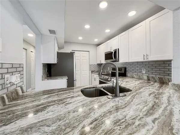 a kitchen with stainless steel appliances a sink a stove a microwave and cabinets