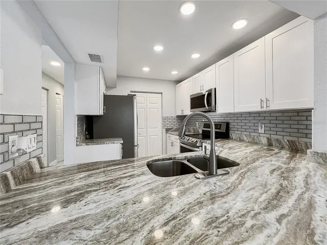 a kitchen with stainless steel appliances a sink a stove a microwave and cabinets