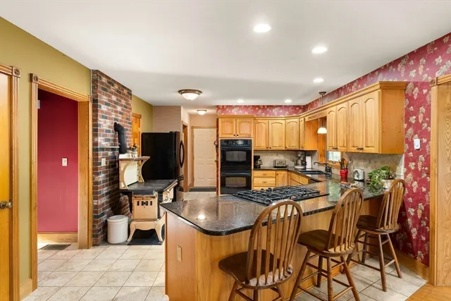 a kitchen with stainless steel appliances kitchen island granite countertop a sink and cabinets