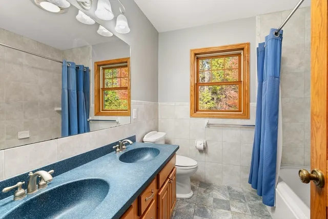 a bathroom with a sink double vanity granite and a toilet