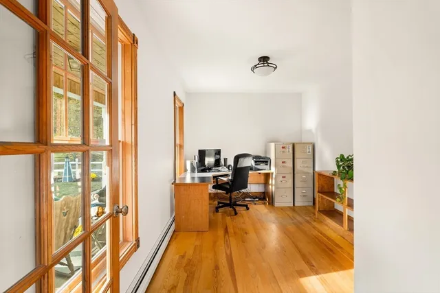 a view of a workspace with furniture and a window