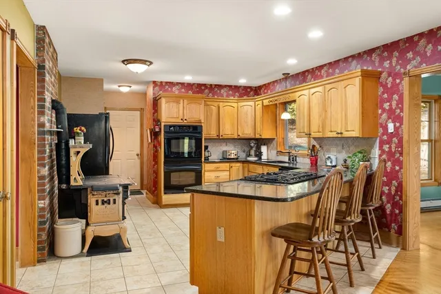 a kitchen with stainless steel appliances granite countertop a refrigerator and a stove top oven