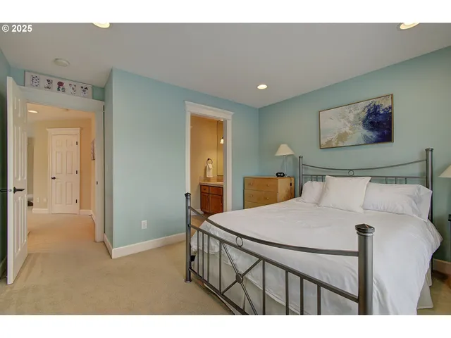 a bedroom with a bed and a painting on the wall