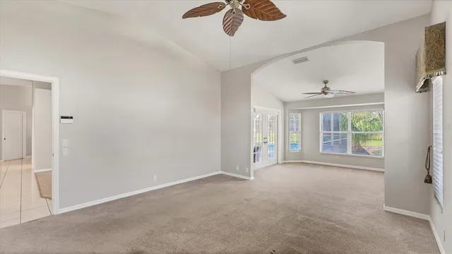 an empty room with a ceiling fan and a window