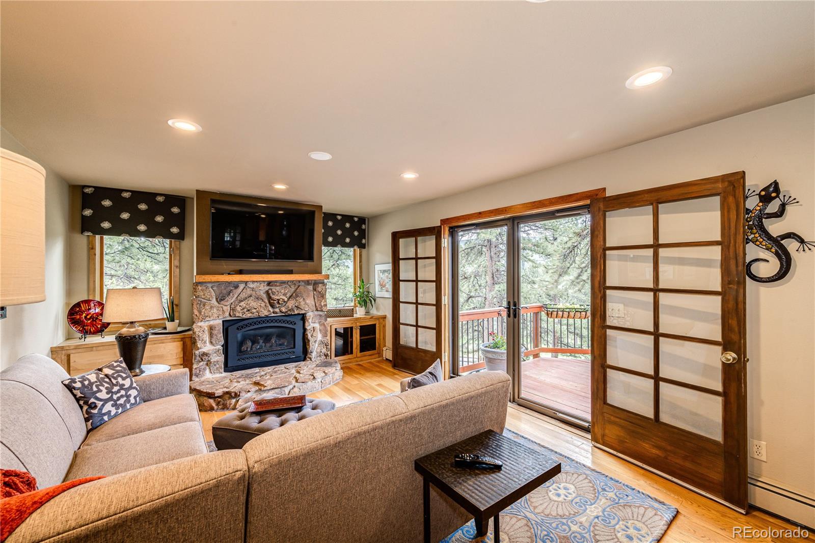 272 Greystone Road Evergreen, CO 80439 - Photo 15 of 40 a living room with furniture a fireplace and a flat screen tv