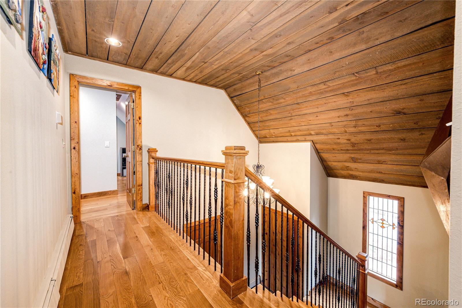 272 Greystone Road Evergreen, CO 80439 - Photo 19 of 40 a view of a hallway with wooden floor and staircase