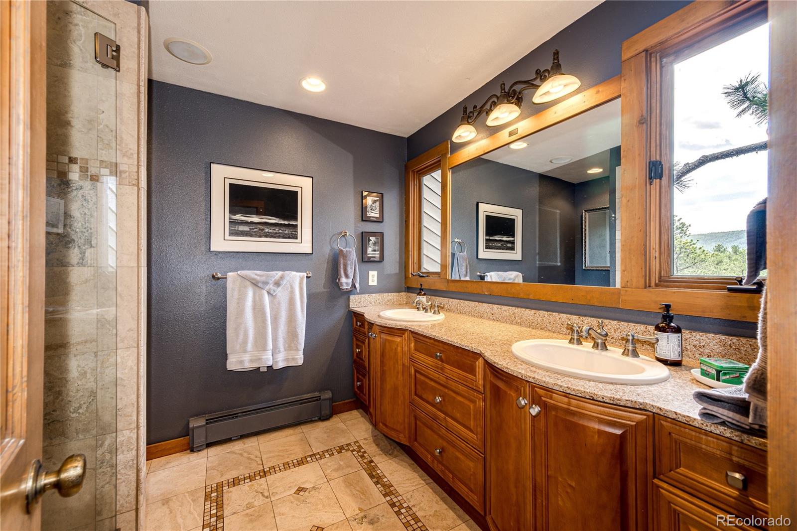 272 Greystone Road Evergreen, CO 80439 - Photo 23 of 40 a bathroom with a sink a mirror and a shower