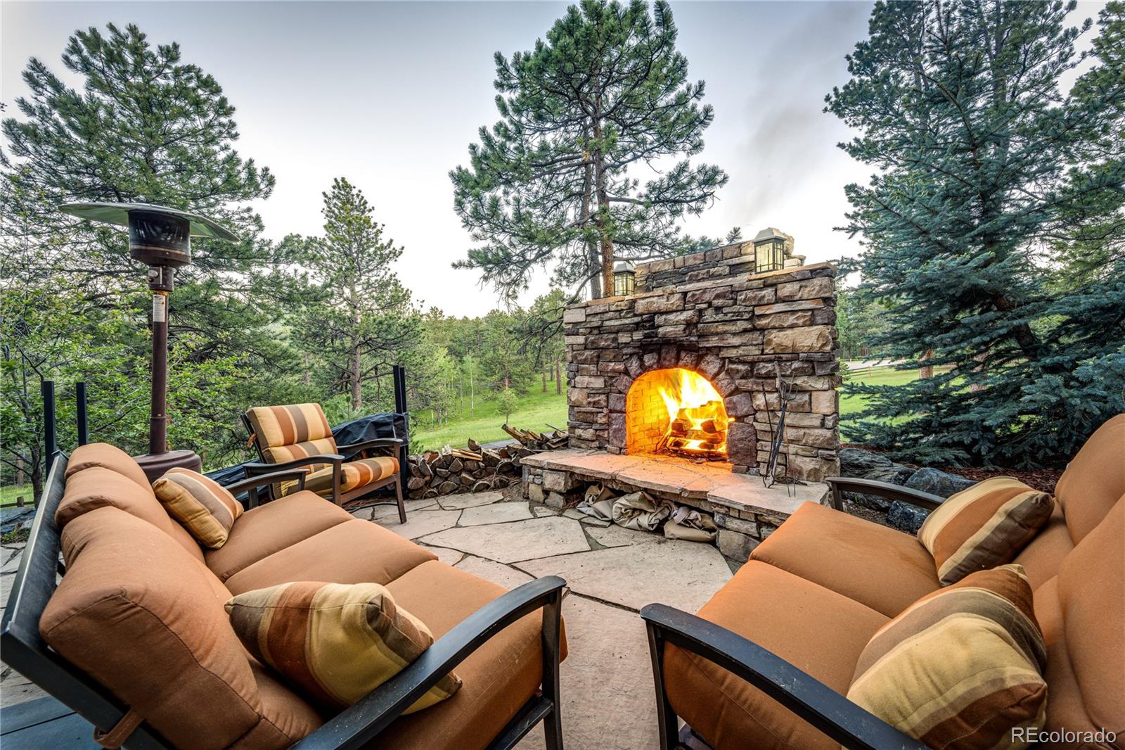 272 Greystone Road Evergreen, CO 80439 - Photo 36 of 40 a view of a patio with couches chairs and a fire pit