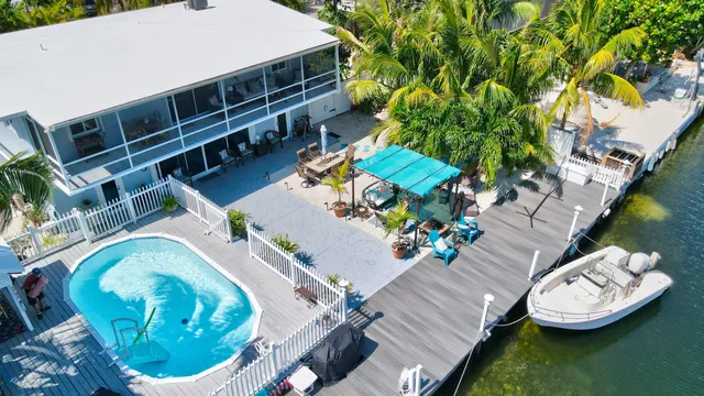 an aerial view of a house with a swimming pool patio and outdoor seating