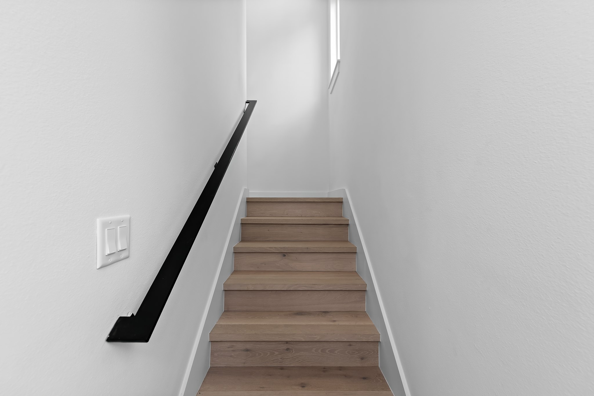5305 Ledesma Road, Unit 4 Austin, TX 78721 - Photo 20 of 40 Smooth wooden stairs ascend, bordered by a sleek, modern handrail.