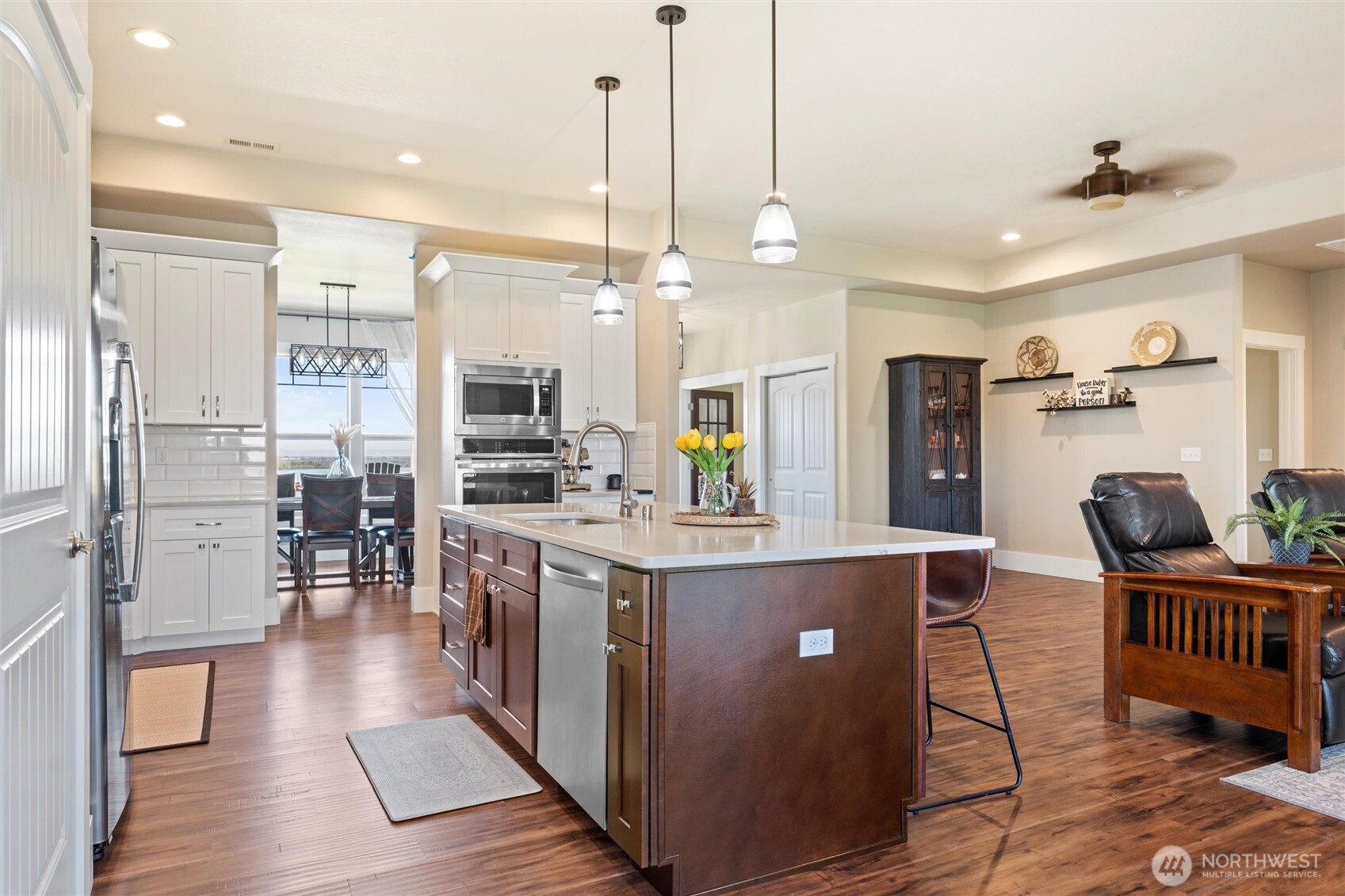8125 Dune Lake Road Southeast Moses Lake, WA 98837 - Photo 14 of 40 a open kitchen with stainless steel appliances granite countertop a refrigerator a stove top oven a dining table and chairs with wooden floor