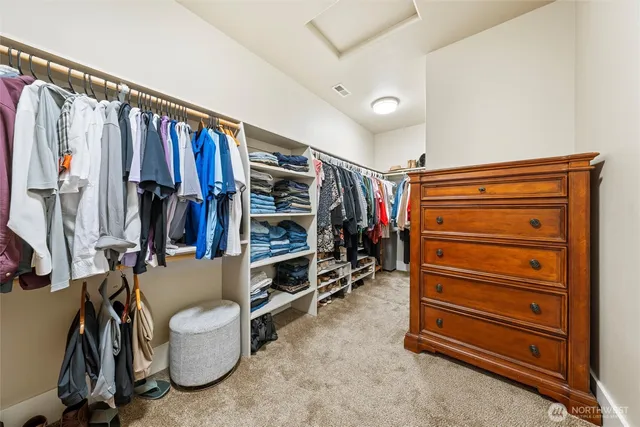 a view of walk in closet with clothes and shoes