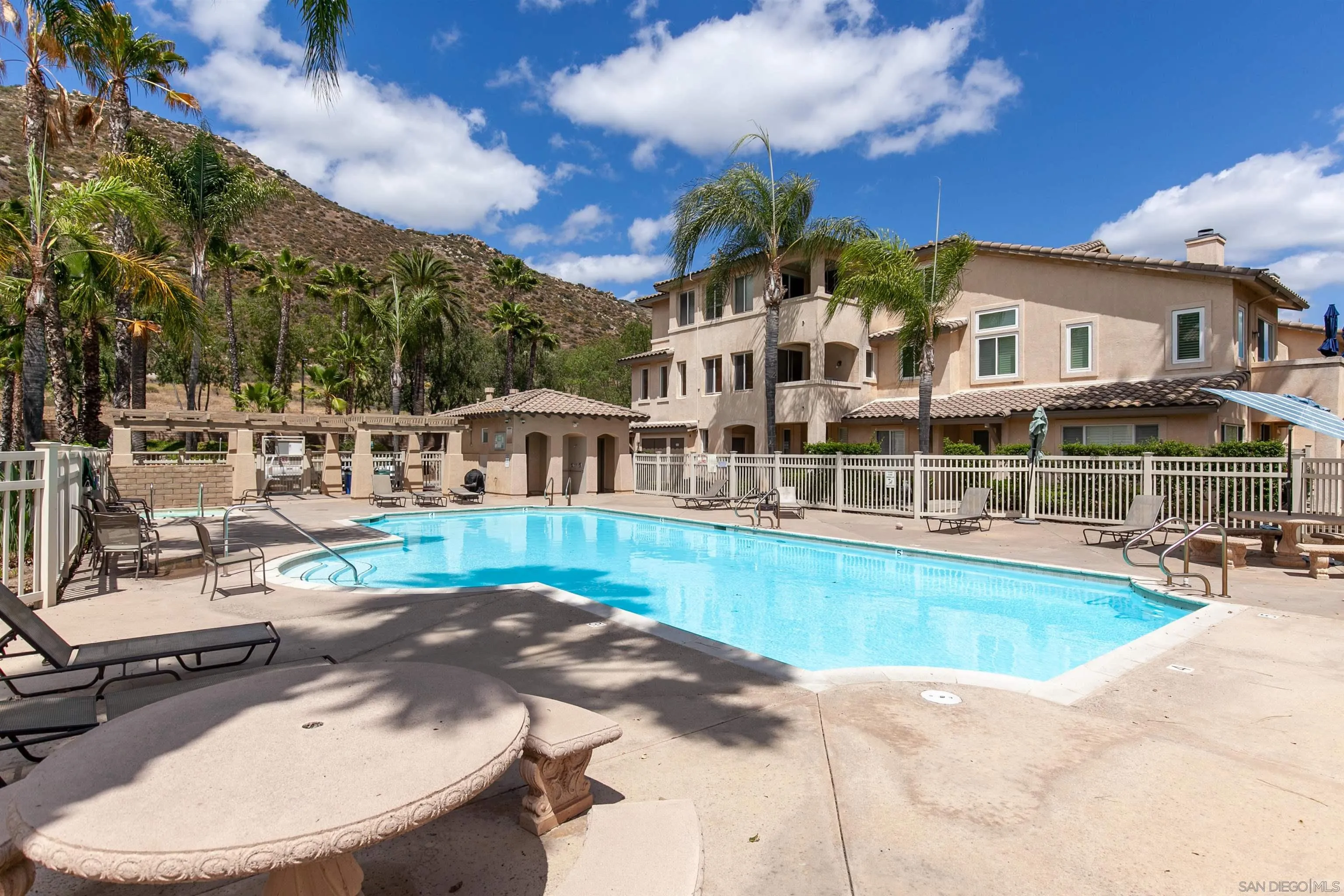 3177 Dehesa Road El Cajon, CA 92019 - Photo 43 of 55 a view of a white house with a swimming pool and sitting area