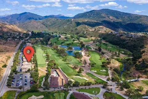 a view of a park with a building and mountains in the background