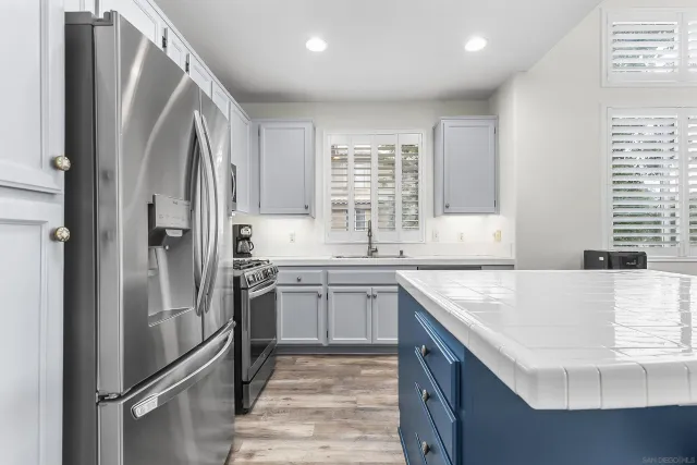 a kitchen with stainless steel appliances granite countertop a refrigerator and a sink