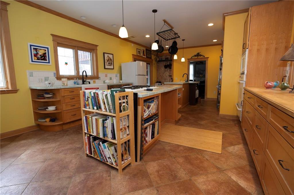 200 School Street Pittsburgh, PA 15205 - Photo 12 of 46 a large kitchen with stainless steel appliances a large counter top a stove a chimney a sink and a refrigerator