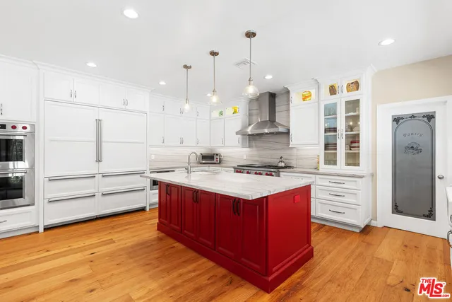 a kitchen with kitchen island sink stove and cabinets