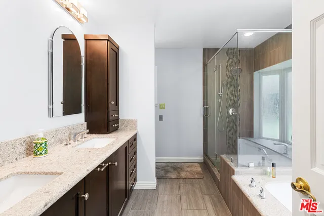 a bathroom with a granite countertop double vanity sink and a mirror
