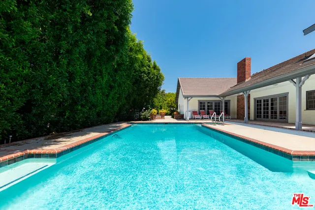 a front view of a house with swimming pool having outdoor seating